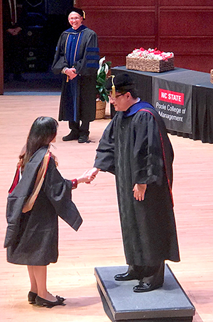 Xintong Ye, who graduated with a master's in economics, received her hood from Xiaoyong Zheng, Professor of Agriculture and Resource Economics and director of Graduate Programs in Economics