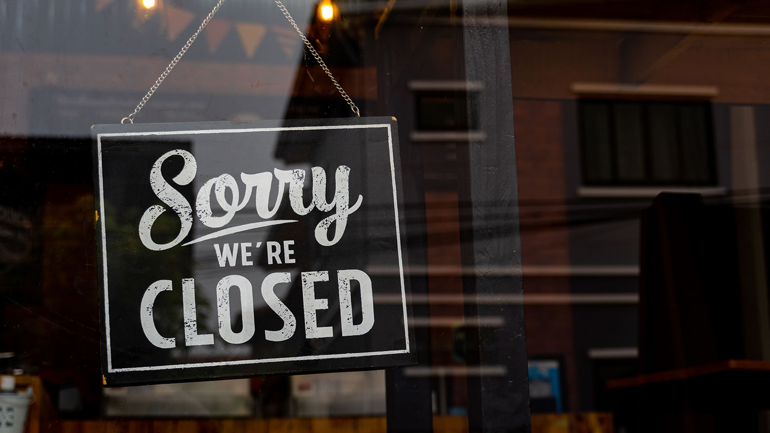 Sign hanging behind glass that says Sorry We're Closed
