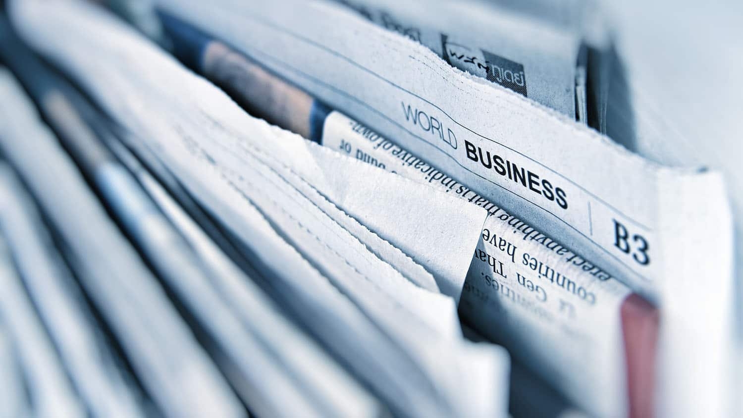 image shows a stack of newspapers. One of the newspapers is sticking out. It is from the World Business section.